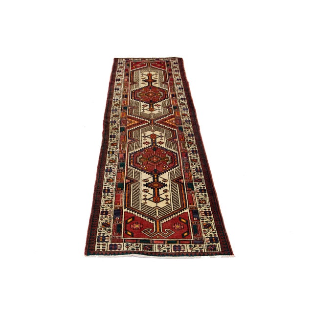 This Beautiful vintage Serab hand-knotted wool runner has an all-over tribal motif with multicolor accents and a red...