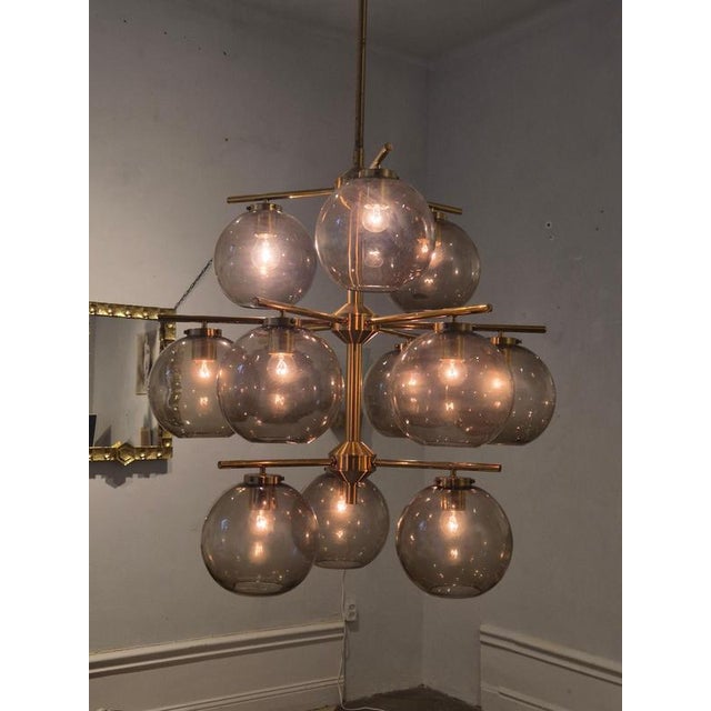 A beautiful chandelier from a church (now private residence) on Gotland, Sweden, in brass with grey transparent shades....