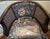 A striking vintage barrel-back accent chair featuring a gracefully curved dark wood frame, woven cane side panels, and...