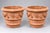A pair of large handcrafted Italian terracotta planters featuring a rolled rim, stepped base, and a repeated decorative...