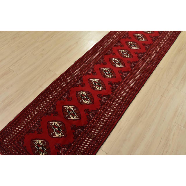 An authentic vintage tribal Turkmen runner, hand-knotted with fine wool and natural dyes. This nomadic rug features a row...