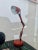 Industrial style table lamp in orange color with mechanical arm for height adjustment. Style: Vintage State: Good...