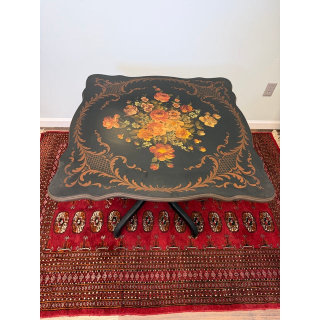 A beautiful vintage hand-painted floral tilt-top table featuring an ebonized finish, intricately painted floral bouquet,...