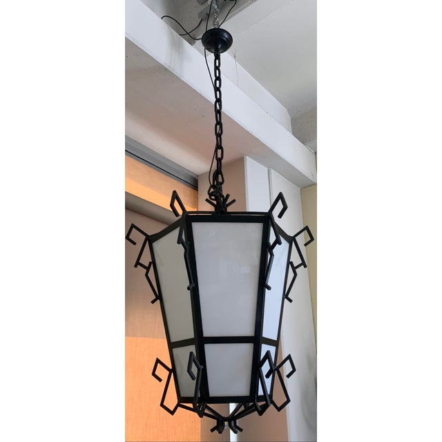 This pair of wrought iron lanterns, dating back to around 1930, features decorative geometric details. they are suitable...