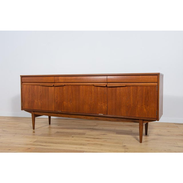 The teak sideboard was produced in Great Britain in the 1960s.The sideboard is a flagship example of the high level of...