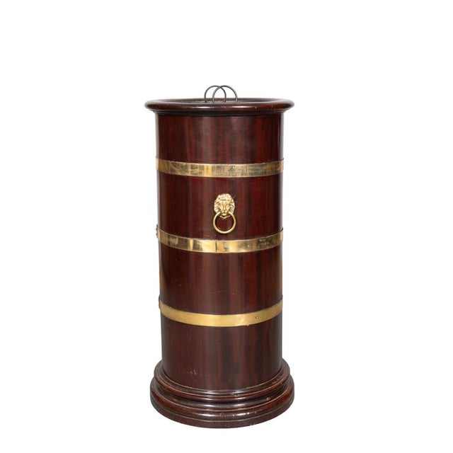 Cylindrical with brass strapping and lions head with rings on sides. Tin liner.