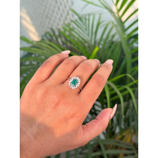 This halo engagement ring features a 0.92-carat natural emerald set in 14K white gold. The center emerald measures...