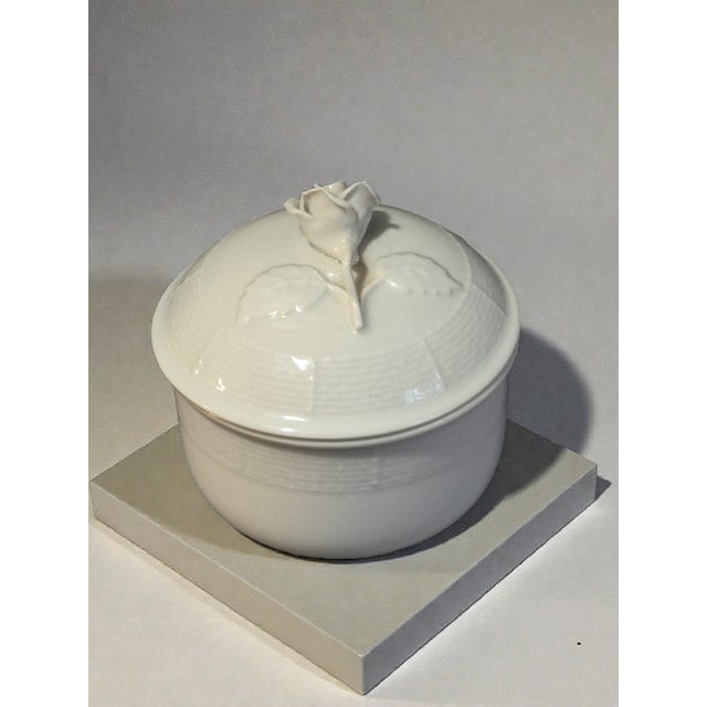 This vintage white fine porcelain trinket box with a rose top design is a charming collectible piece from the late 20th...