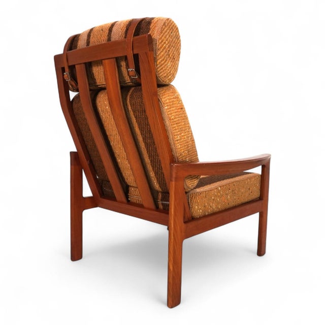 A striking Danish lounge chair from the 1960s, where warm teak wood and an exceptional, original wool fabric combine to...