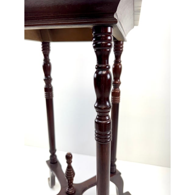A mid-20th century English Regency Revival plant stand featuring a solid white marble top with elegant gray veining...