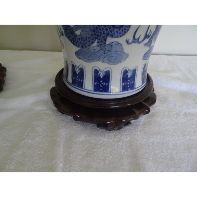 A beautiful pair of Blue and White vases with intricately carved stands that makes an important presentation.