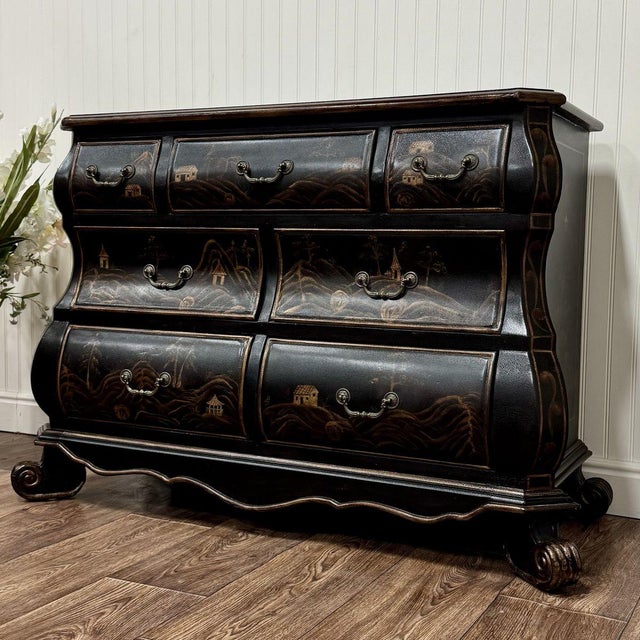 Striking black Chinoiserie style bombe chest featuring a richly textured lacquer-style finish and hand-painted Asian-...