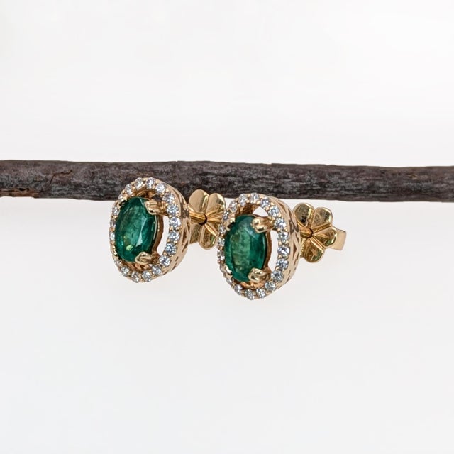 This sparkling earring set features a pair of vibrant earth mined emeralds with a pave diamond halo in solid 14k gold. A...