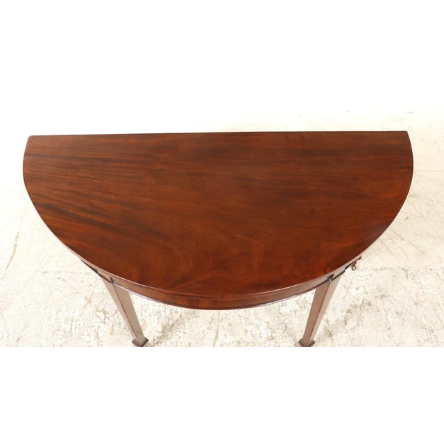 This late 18th - early 19th century table features elegantly tapered legs ending on casters. Appears to be the end portion...