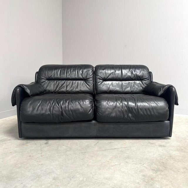 Remarks: Mid century sofa by Dreipunkt, Germany 1970s. Strong and heavy wooden frame with black leather upholstery. All...