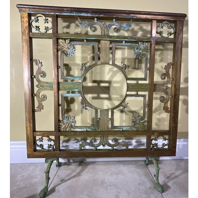 Transform your hearth into a focal point of refined elegance with this stunning antique bronze and brass fireplace screen....