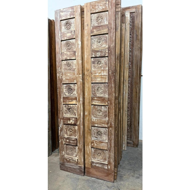 A striking pair of vintage hand-carved closet doors crafted from solid reclaimed wood, featuring intricate floral motifs...