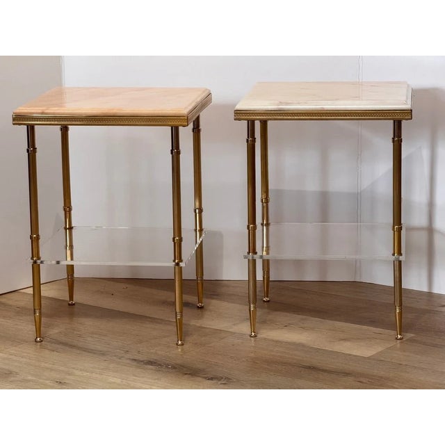 Pair of French brass side tables, in the manner of Maison Jansen, 20th c., each having inset bevel-edge marble top, over...