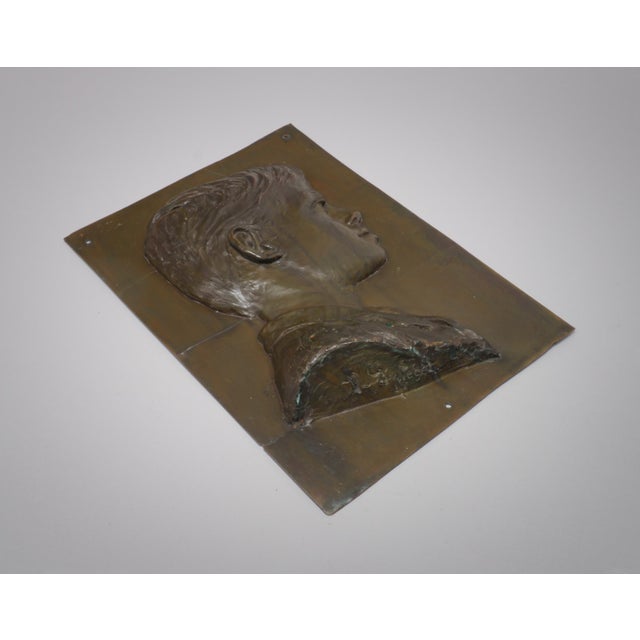 A 1930s patinated bronze wall-mounted plaque or sculpture in bas-relief depicting a boy or a young man. It dates to the...