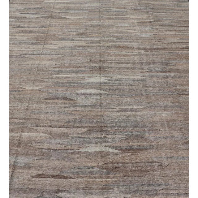This flat-weave kilim has been hand-woven. The rug features an all-over solid/diamond design, rendered in gray, neutral...
