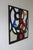 Black lines intersect on a beige and white background, revealing touches of primary colors such as red, blue, green, and...
