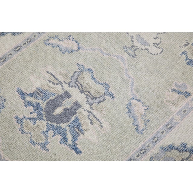 This modern Turkish Oushak rug is a stunning piece of art that has been handwoven using traditional techniques by skilled...