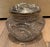 Turn of century Antique boudoir jar with decorative silverplate lid and etched glass detail on jar.