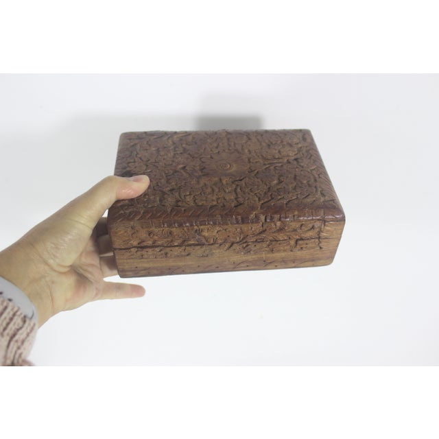 Lovely carved wood trinket box with a hinged lid. The hinged lid opens easily. The carving is a gorgeous floral motif....