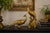 Striking vintage Syroco pair of sculptural gold peacocks in classic Hollywood Regency style. This dramatic matched pair...
