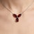 Elegant and captivating, this exquisite necklace showcases the timeless beauty of deep red gemstones in a refined, nature-...