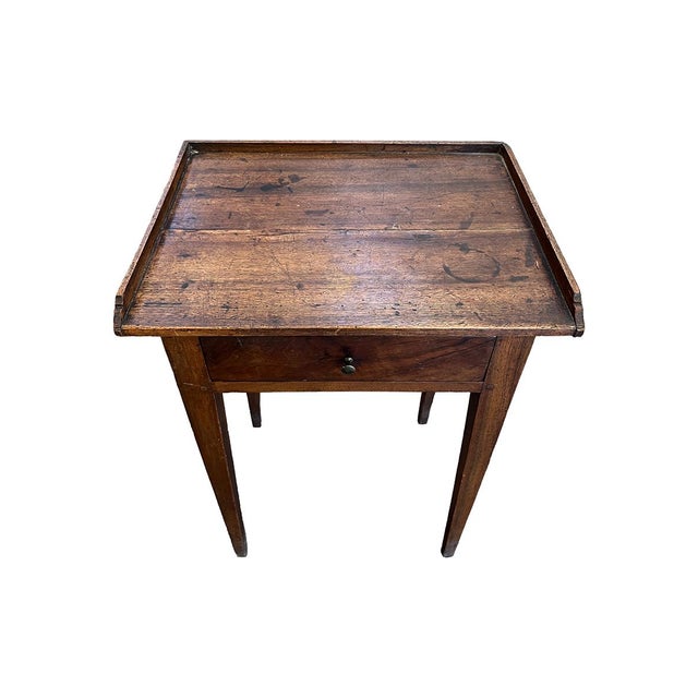 This 18th-century side table is in very sturdy, usable condition. It is crafted with walnut and has a small drawer with a...