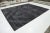 This hand-knotted wool rug in contemporary Moroccan style features a rich charcoal gray field with a striking white...