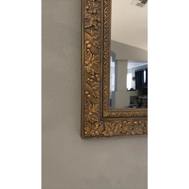 A striking vintage mirror by Home Interiors & Gifts, featuring an exceptionally ornate molded frame decorated with...