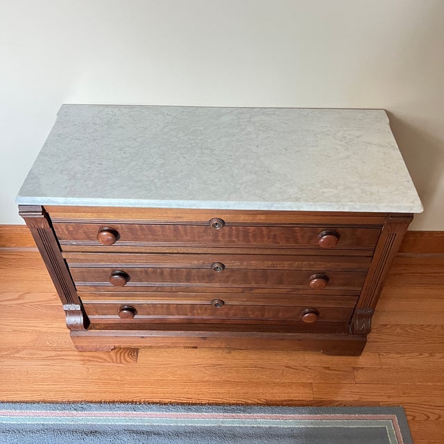 Antique 3 drawer chest of drawers with marble top. Carved wood front with scroll sides and wood knobs. (Marble top lifts...