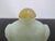 Antique Chinese hand-carved jade snuff bottle featuring a pale celadon hue and symmetrical carved mock mask ring handles....