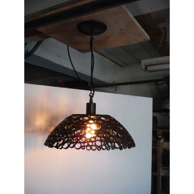 Inspired by the work of Queens’s lamp designer Louis comfort Tiffany this pendant associates steel, bronze and light for a...