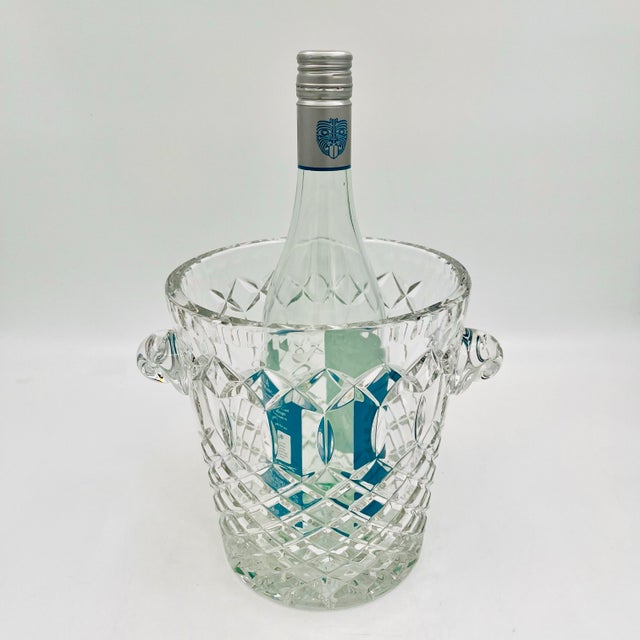 Vintage cut crystal ice bucket or champagne cooler is designed with a diamond pattern and two scrolled handles. Unmarked,...