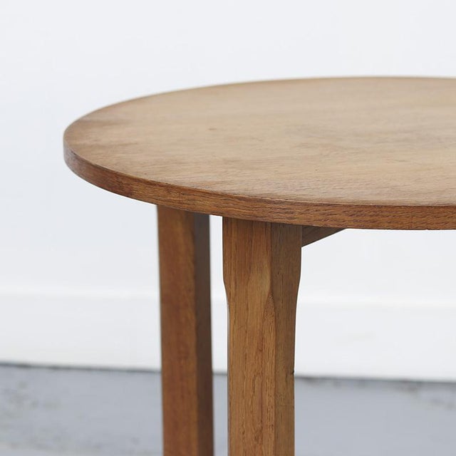 Art Deco side table from the 1930s, featuring an elegant solid oak base and a veneered top. An elegant and decorative...