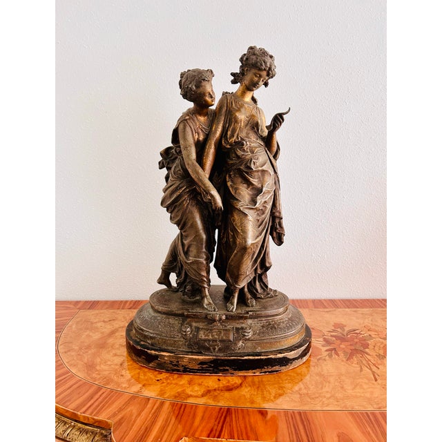 This striking Art Deco sculpture of two Grecian maidens is an early 20th century replica of L. F. Moreau’s ‘Confidence’....