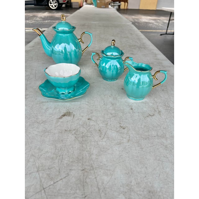 This stunning set is finished in a high-gloss, shimmering teal glaze that catches the light beautifully, accented by...