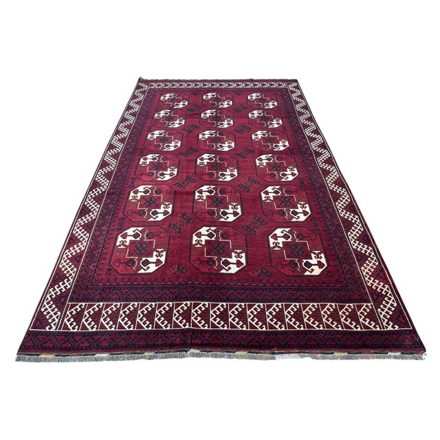 Vintage Afghan Elephant Foot rug, hand knotted in Afghanistan from 100% wool. Measuring 7’2” x 10’4”, this striking tribal...