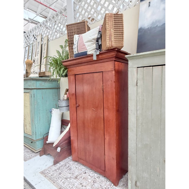 Crafted from solid pine, the cabinet stands tall and narrow—exactly the proportions you’d expect from an early pantry...