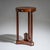 Empire gueridon in walnut, standing on three tall columnar legs with a trefoil base and central plinth. The sides are...