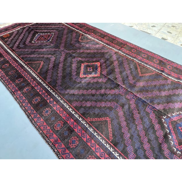 A dramatic antique herati Baluch tribal gallery runner — three massive concentric diamond medallions radiate outward in...
