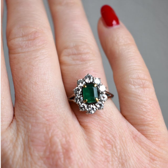 A stunning and timeless French daisy cluster ring (circa 1990), crafted in 18k white gold. This exquisite piece features a...