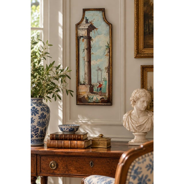 A distinctive Italian capriccio landscape, painted in oil on a shaped panel and presented in a softly worn giltwood frame....