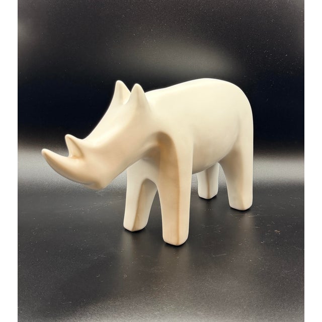 A sculptural matte white rhino with a clean, modern silhouette an understated yet striking decorative object designed to...