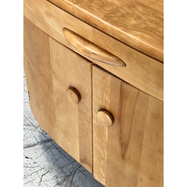 Mid century modern blonde cabinet by Heywood Wakefield, featuring a curved front design, single wide drawer and open...