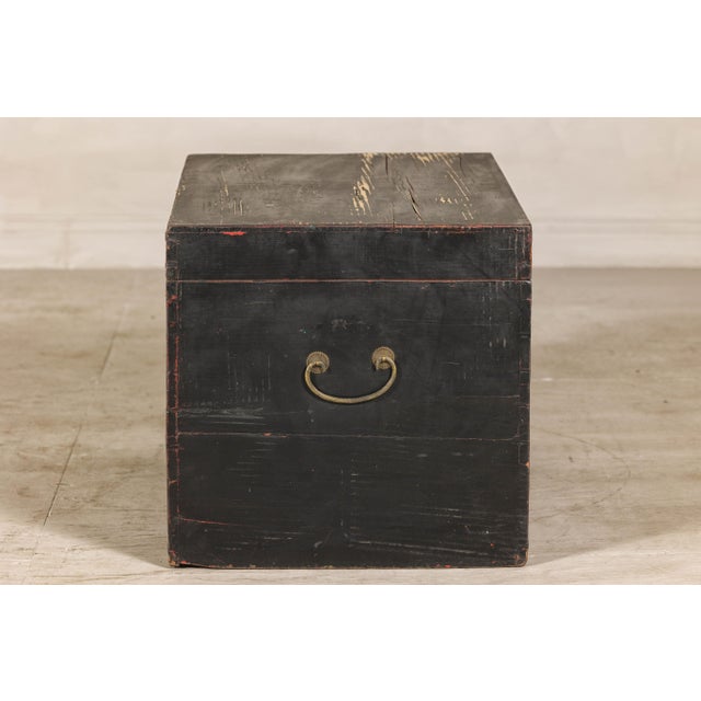 A Qing Dynasty black lacquered elm blanket chest from the late 19th, early 29th century, with weathered patina. Crafted in...