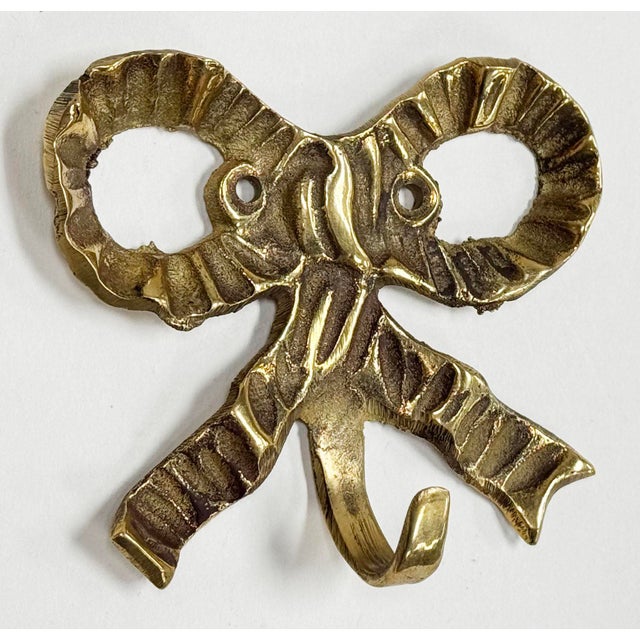 Vintage brass ribbon bow motif wall hook. Holes for hanging. Lovely patina.